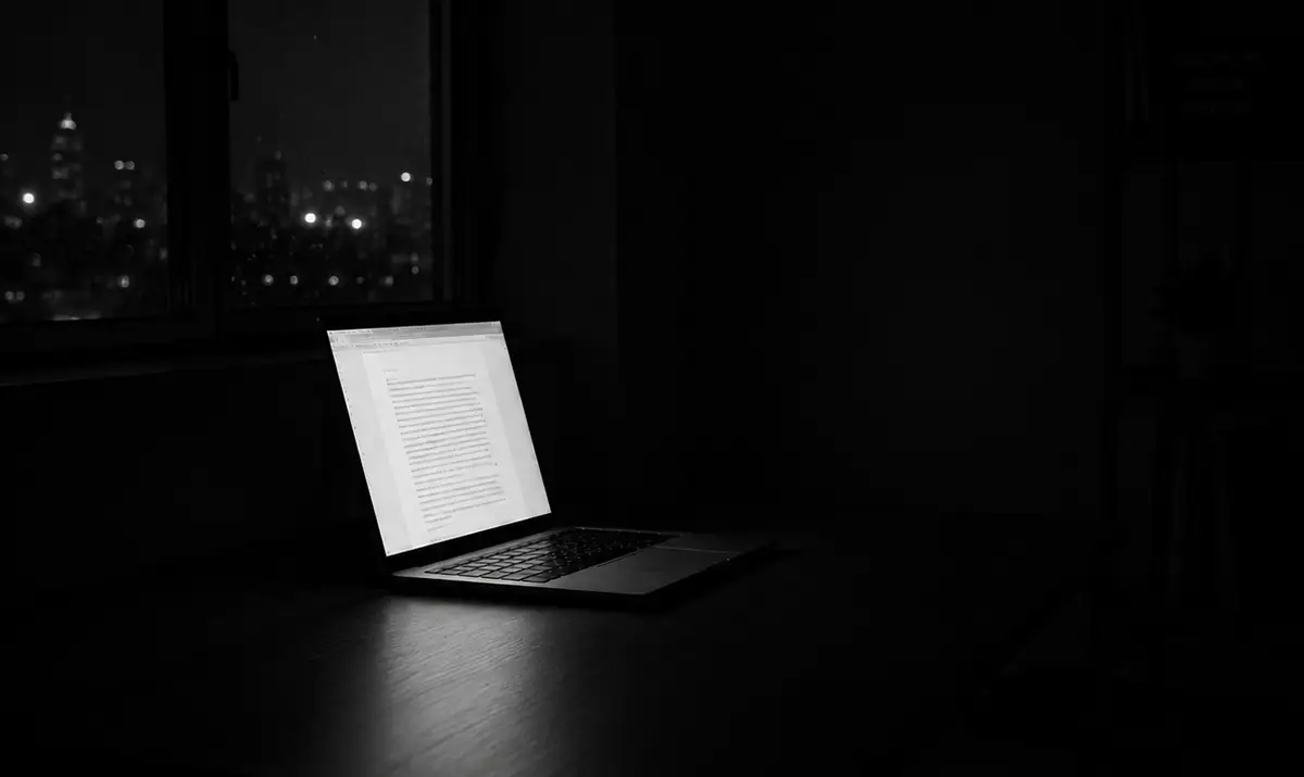 Open laptop glowing in a dark room at night, symbolizing deep work, extreme focus, and uninterrupted execution.